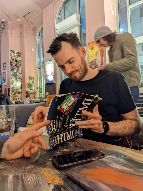 Me studying a big black book that has the letters HTML written on it.