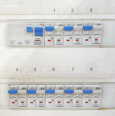 Fuse box panel with blue-grey double switches that are labelled from 1 to 8.