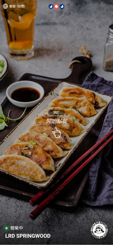 "An interface showing a picture of dumplings with chopsticks next to it. There's an overlay with a Cantonese text and a pointing finger indicating to the text above."